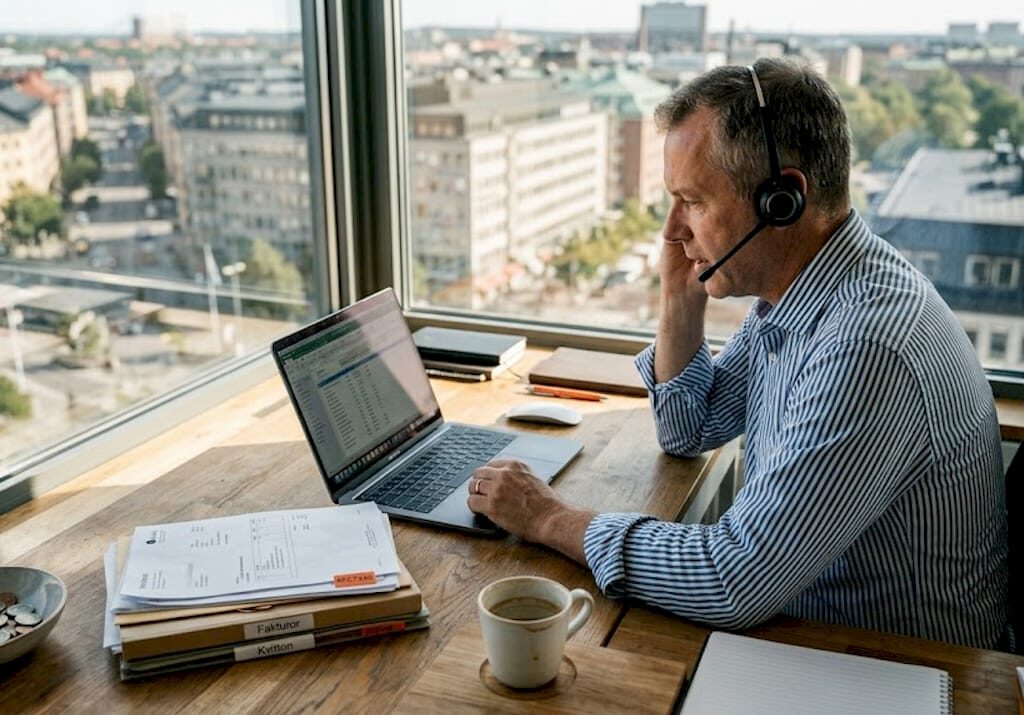 En företagare sitter vid skrivbordet och får experthjälp med IT-frågor.