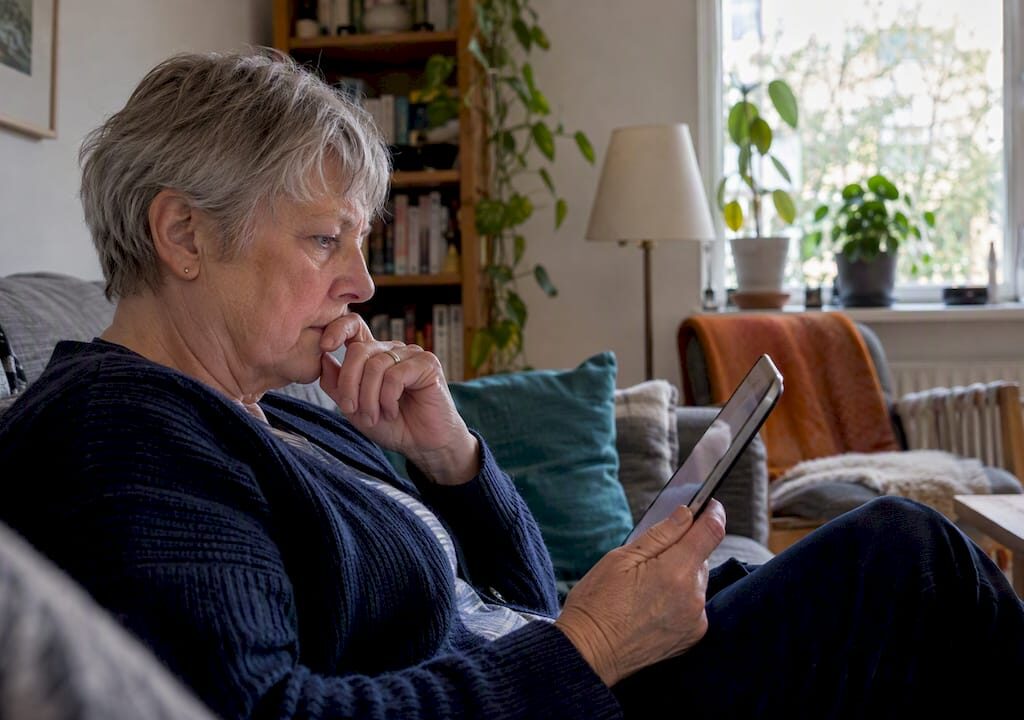 En person läser ett mejl på sin surfplatta hemma